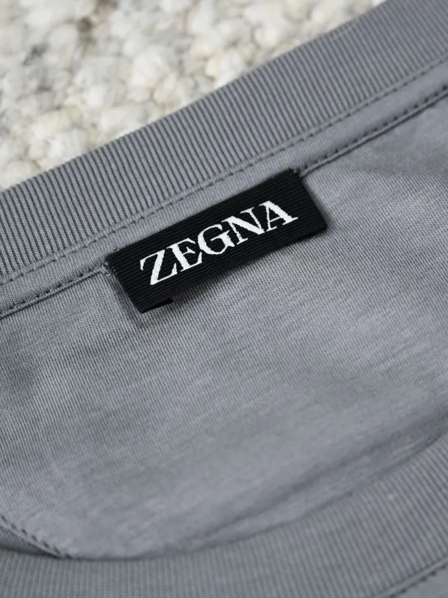 Серая футболка Zegna крупным планом с тканой брендированной биркой у воротника