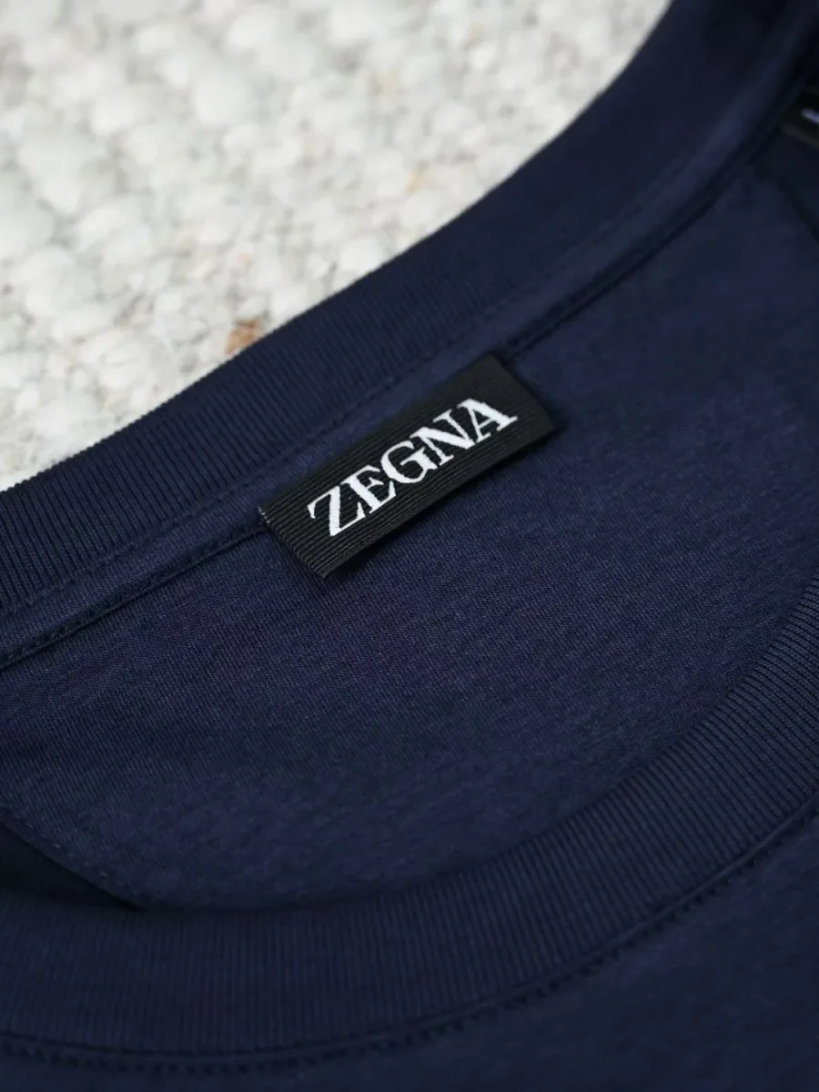 Синяя футболка Zegna крупным планом у горловины, ребристый воротник и фирменная бирка