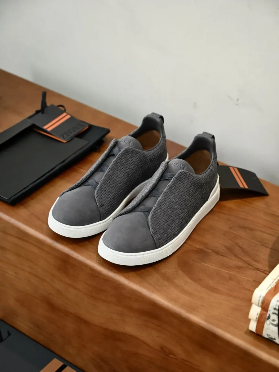 Серые кроссовки Zegna в боковом ракурсе, с фактурными текстильными вставками и белой подошвой