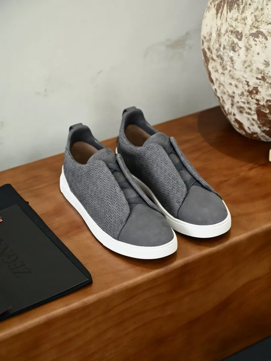 Пара серых текстильных кроссовок Zegna в ракурсе спереди, с округлыми носками и белой подошвой