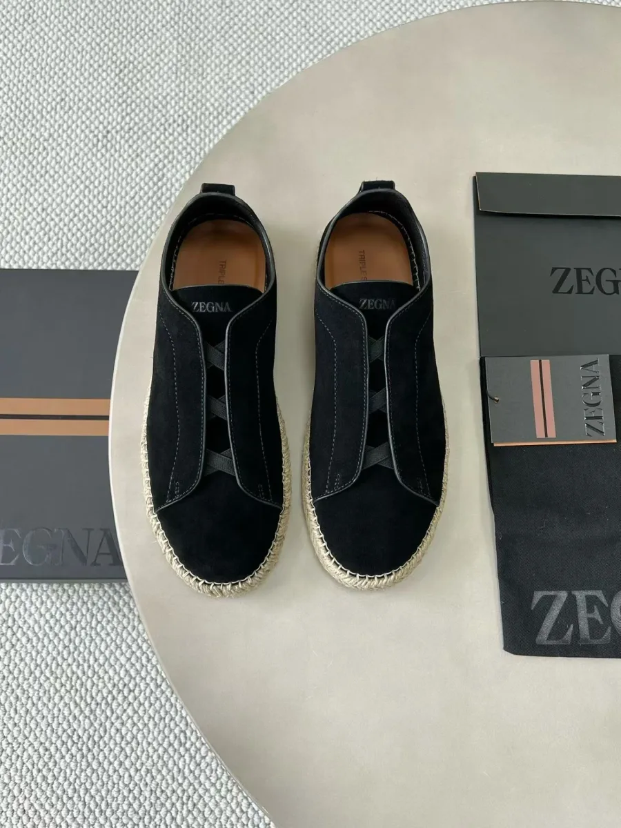 Пара чёрных кроссовок Zegna Triple Stitch сверху, видны декоративные швы и светлая плетёная подошва