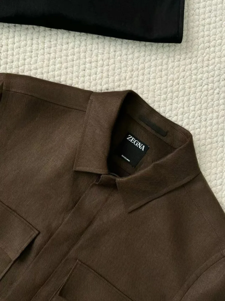 Крупный вид воротника тёмно-коричневой рубашки Zegna с чёрной брендированной этикеткой