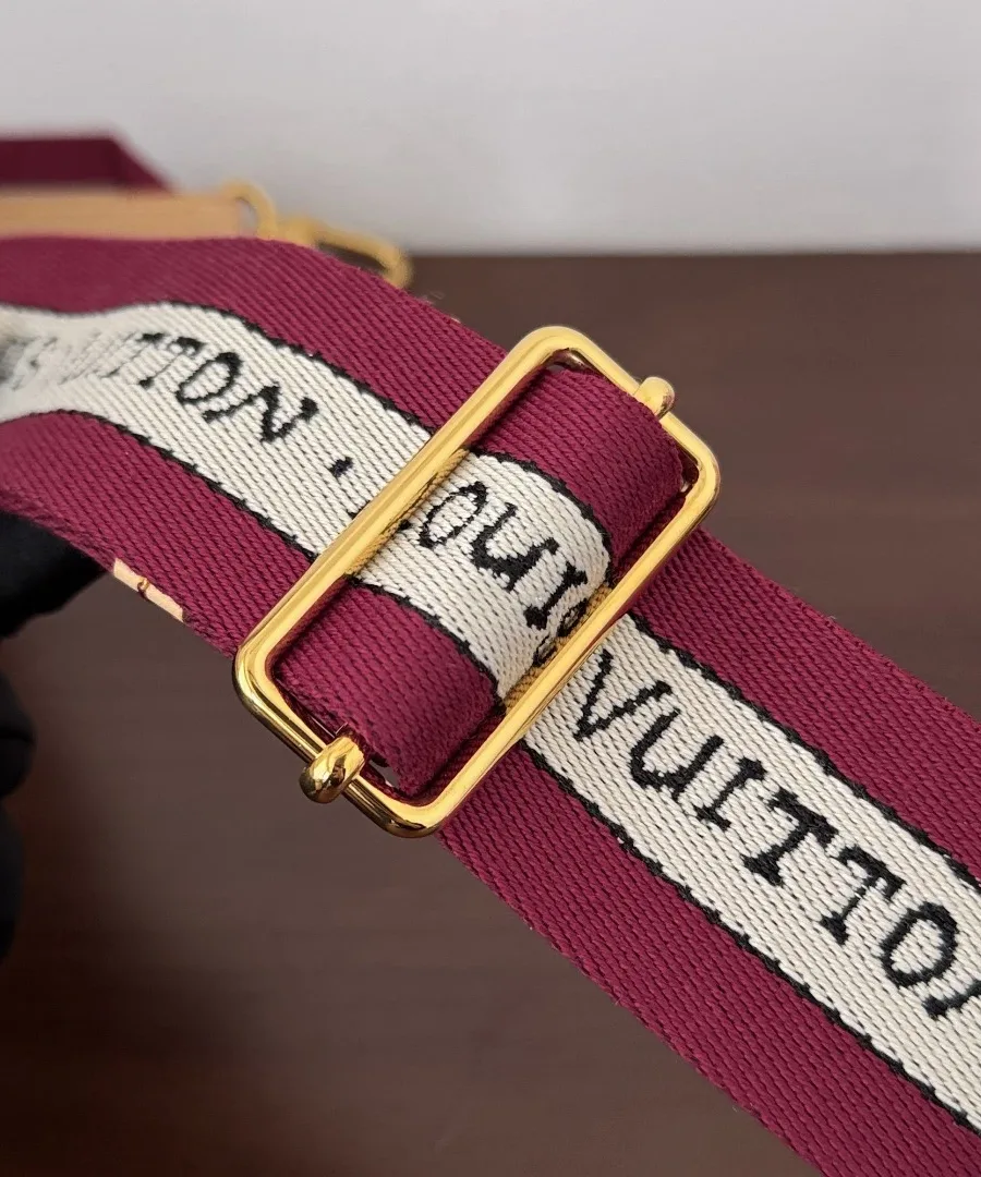 Текстильный плечевой ремень бордового цвета с надписью Louis Vuitton.