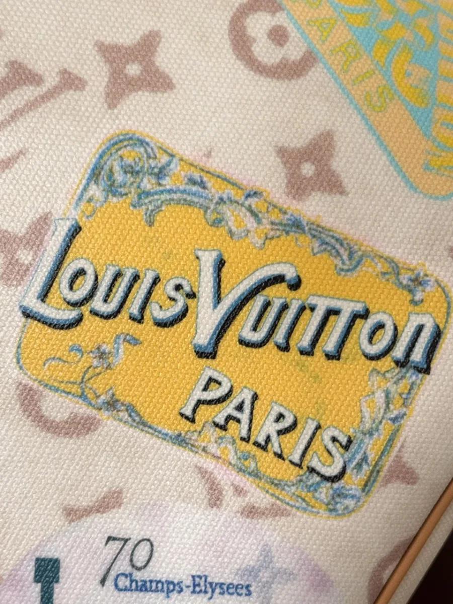 Крупный план принта в виде желтой марки с надписью Louis Vuitton Paris