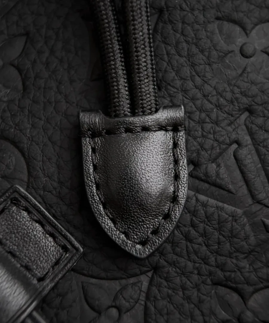 Крупный план тисненой кожи Monogram и кожаного элемента шнурка