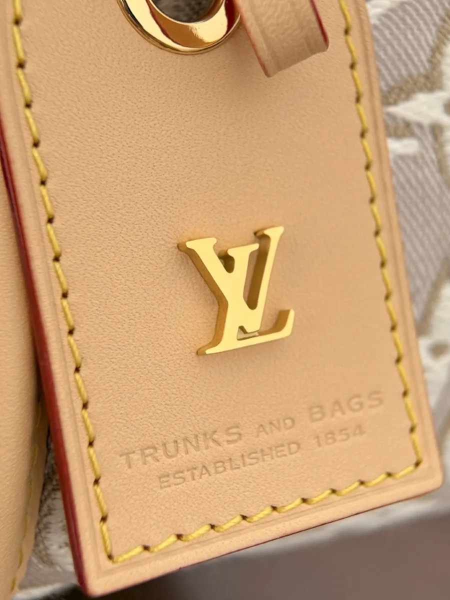 Крупный план кожаной бирки с золотистым логотипом LV Trunks and Bags