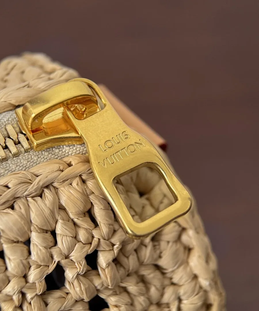 Крупный план золотистого пуллера молнии с гравировкой Louis Vuitton