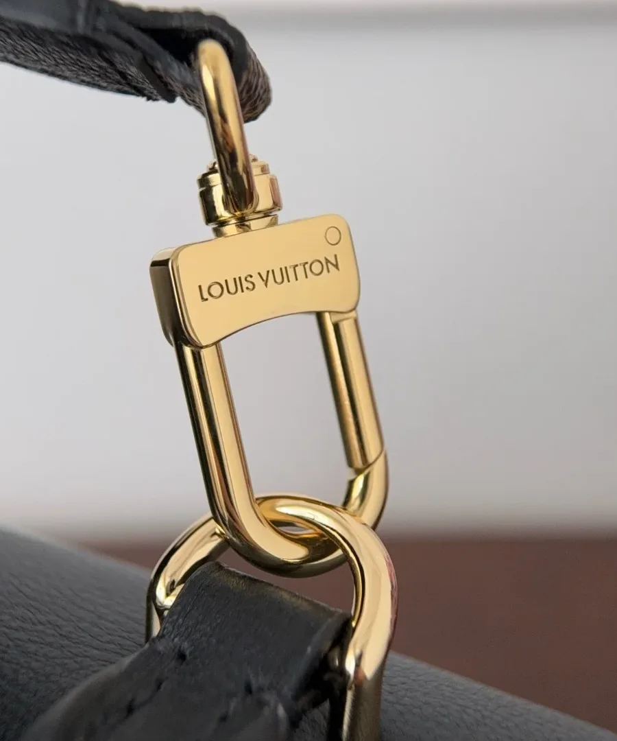 Золотистый карабин с гравировкой Louis Vuitton на плечевом ремне