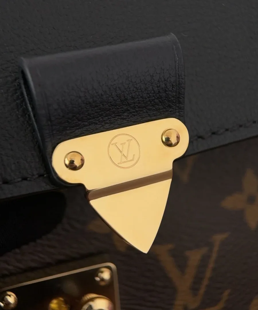 Золотистый замок-защелка S-lock на черном кожаном клапане сумки Louis Vuitton