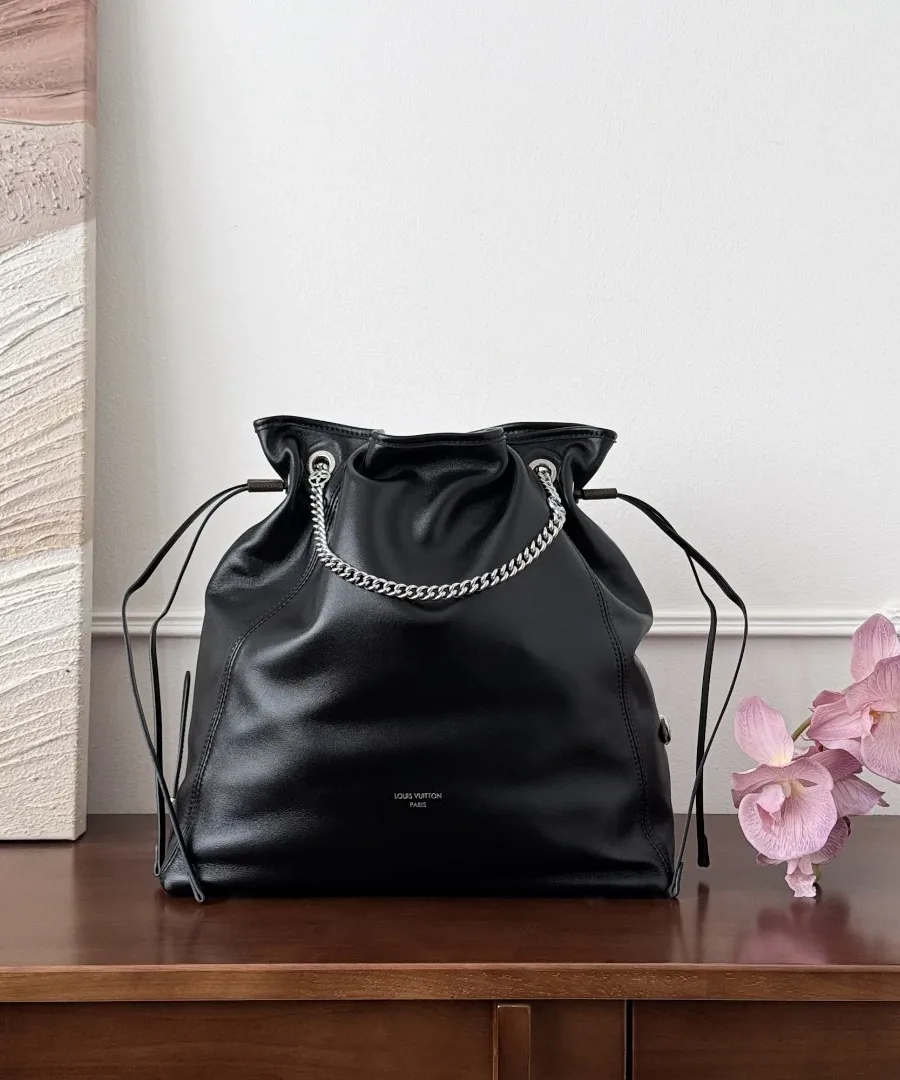 Черная кожаная сумка-мешок Louis Vuitton Off Duty на деревянном столе, вид спереди