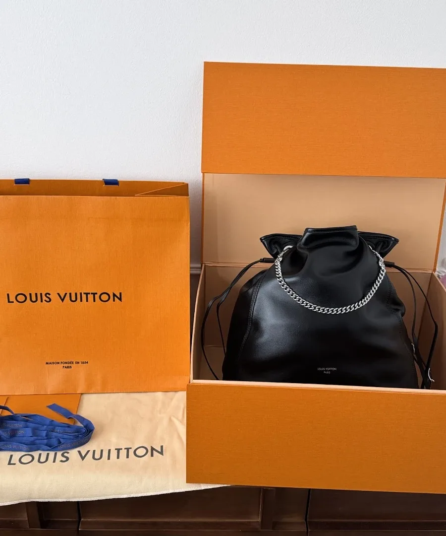 Черная сумка Louis Vuitton Off Duty рядом с фирменной оранжевой коробкой и пакетом