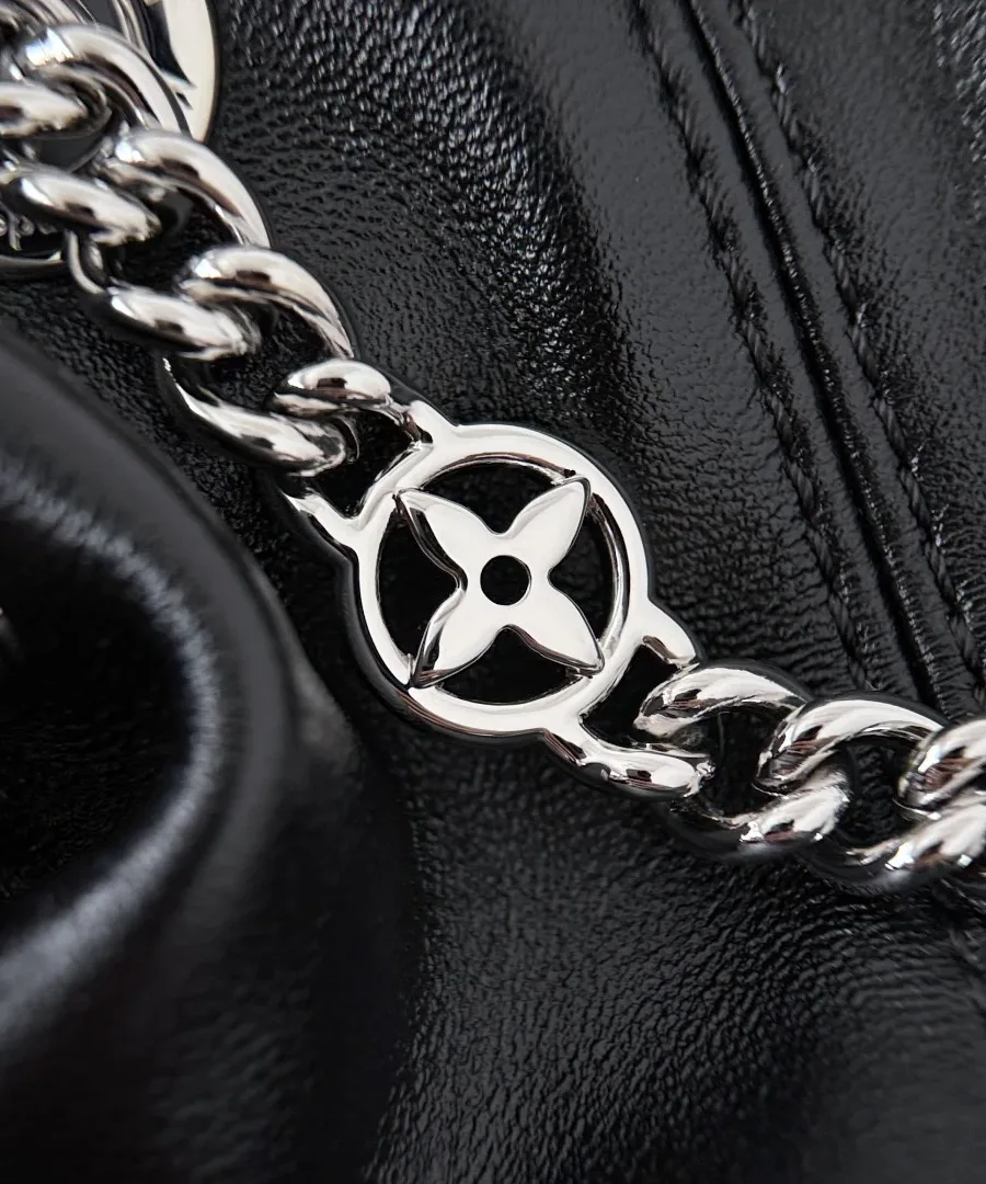 Крупный план серебристой цепочки с металлическим цветком Monogram