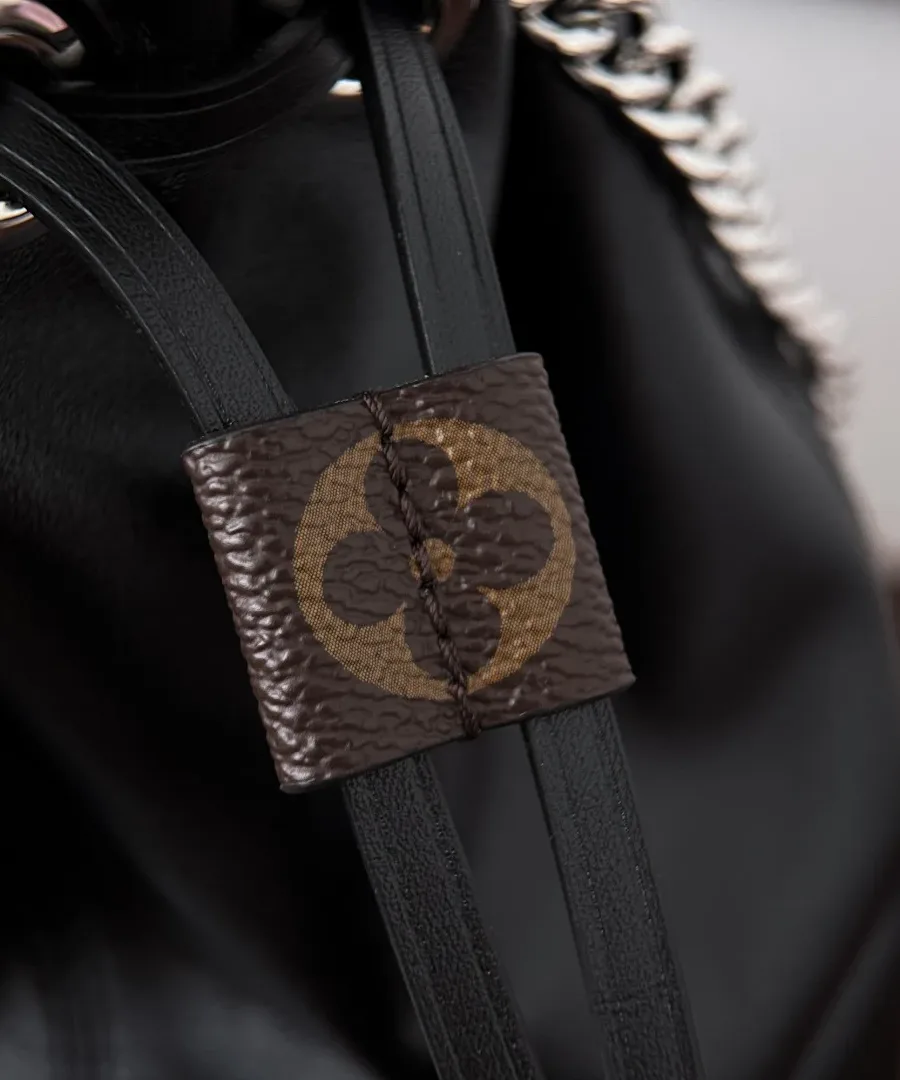 Крупный план кожаного шнурка с квадратной деталью из канвы Monogram