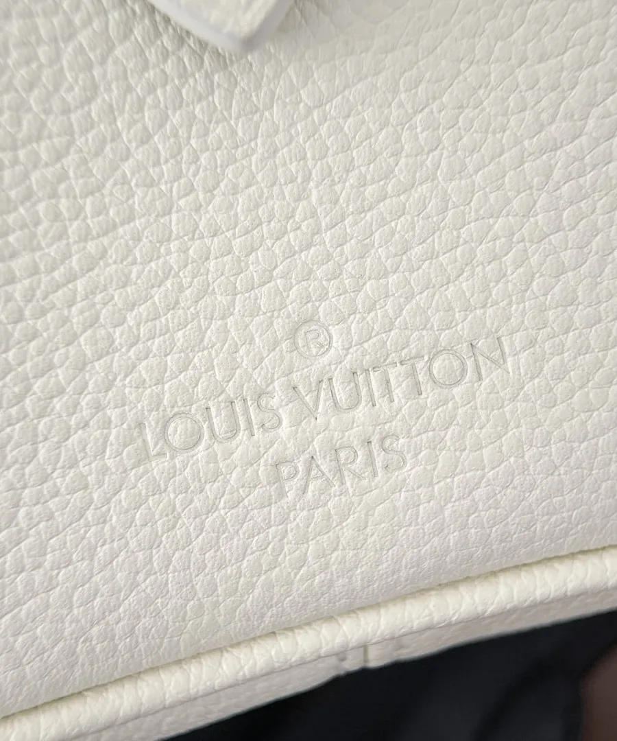 Крупный план зернистой кожи белого цвета с тиснением Louis Vuitton Paris