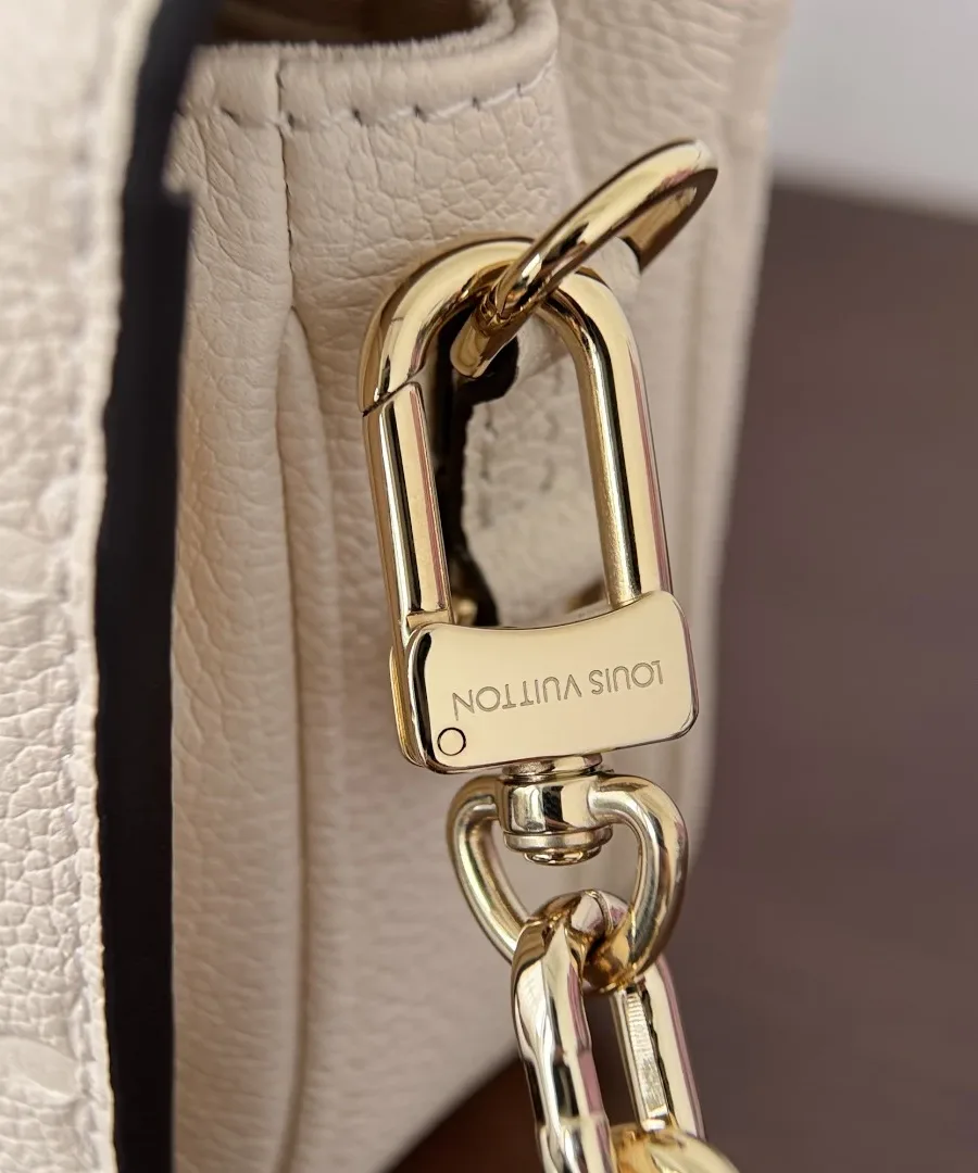 Крепление золотистой цепочки к сумке Louis Vuitton