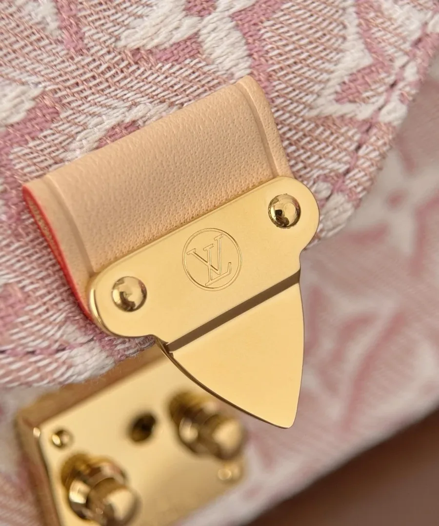 Крупный план золотистого замка S-lock на клапане розовой сумки Louis Vuitton