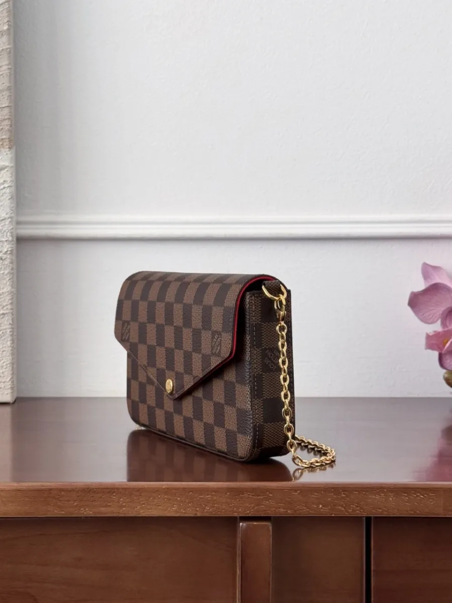 Коричневая сумка Pochette Félicie в клетку Damier Ebene, вид сбоку с золотистой цепочкой