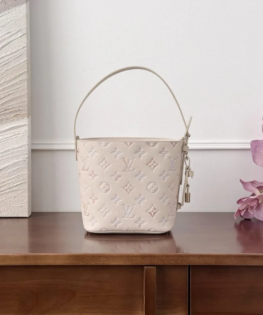 Вид спереди бежевой сумки-ведра Louis Vuitton Bella с короткой ручкой