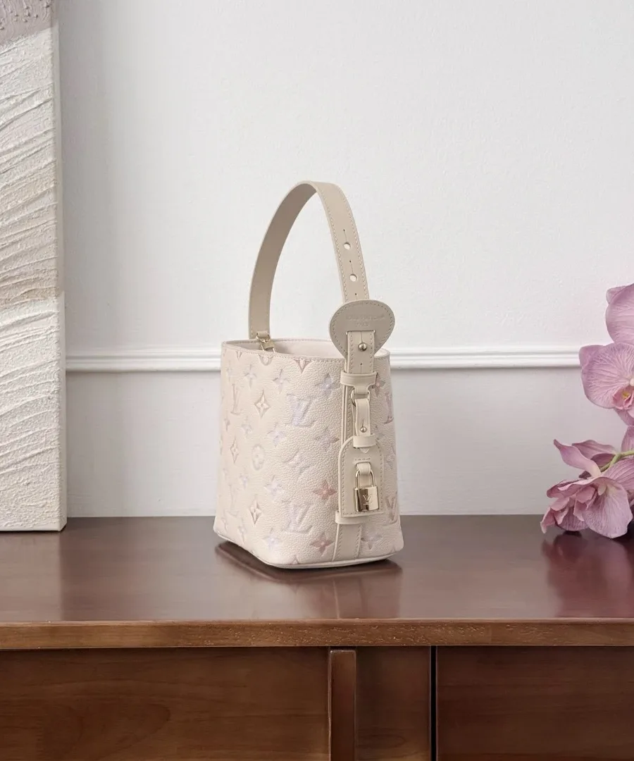 Вид сбоку бежевой сумки-ведра Louis Vuitton Bella