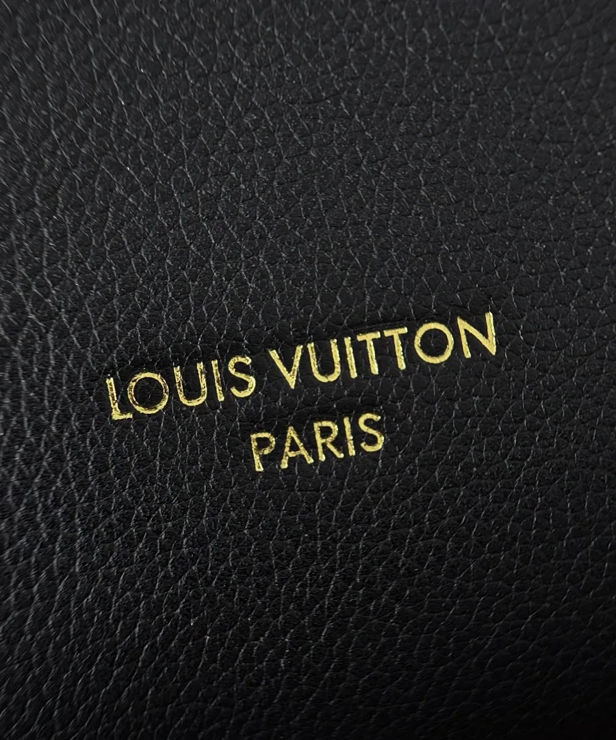 Золотистый тисненый логотип Louis Vuitton Paris на черной зернистой коже