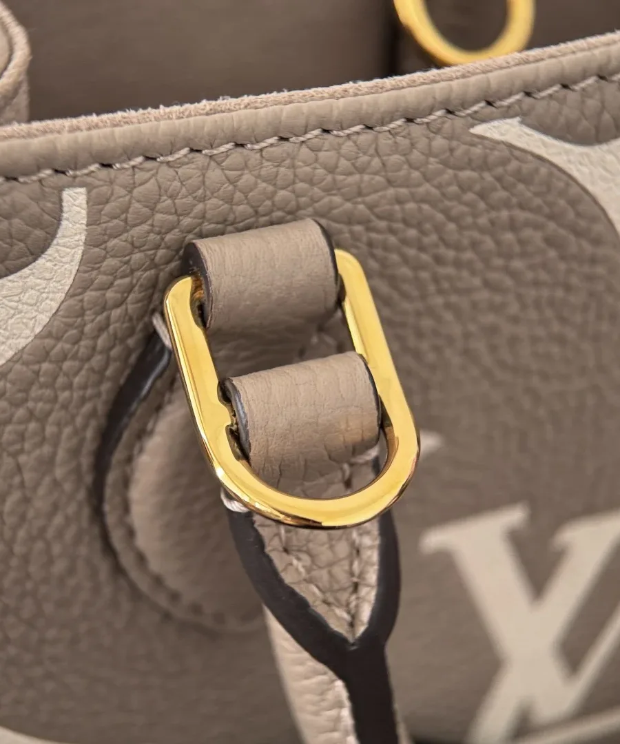 Деталь золотистого металлического крепления ручки сумки Louis Vuitton