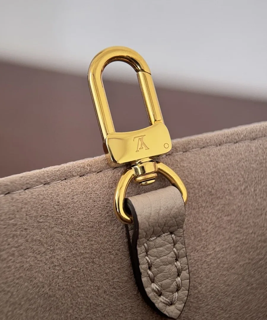 Золотистый карабин плечевого ремня сумки Louis Vuitton крупным планом