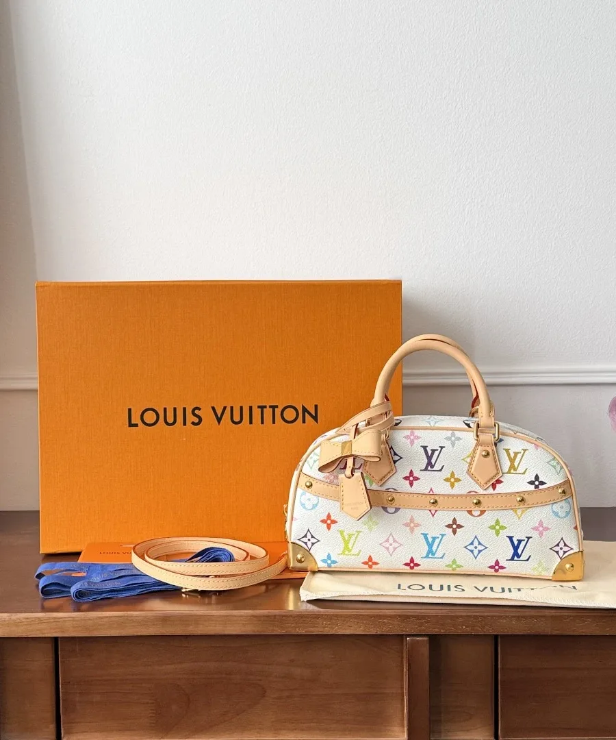Белая сумка Louis Vuitton рядом с фирменной оранжевой коробкой и пыльником