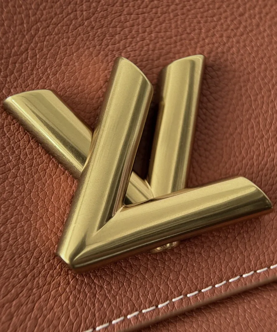 Крупный план золотистого поворотного замка LV на коричневой коже