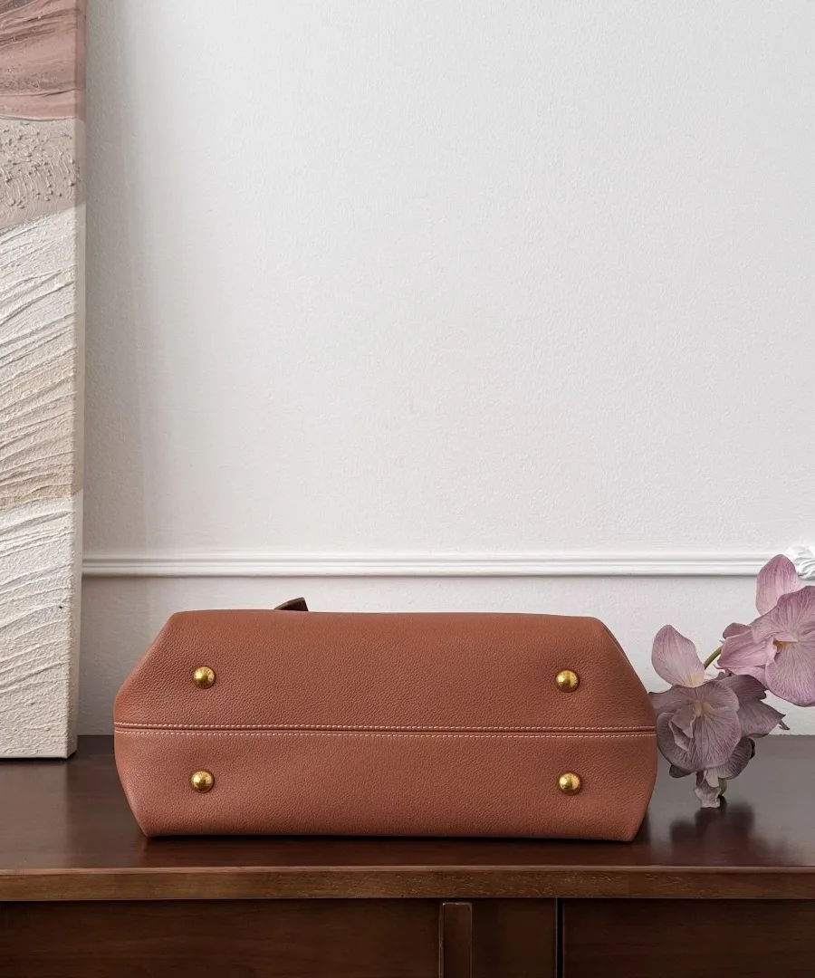 Дно коричневой сумки Louis Vuitton Low Key Cabas с четырьмя металлическими ножками