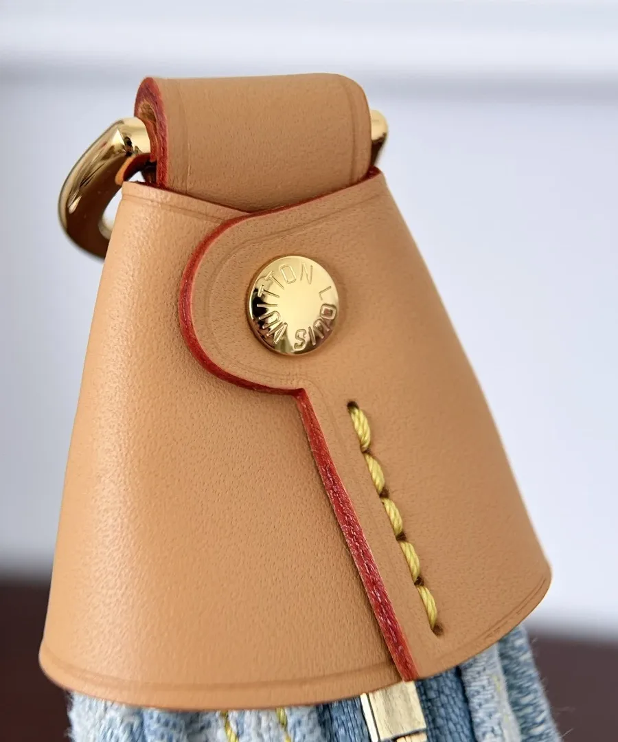 Деталь кожаной отделки сбоку сумки Louis Vuitton Loop с золотистой заклепкой