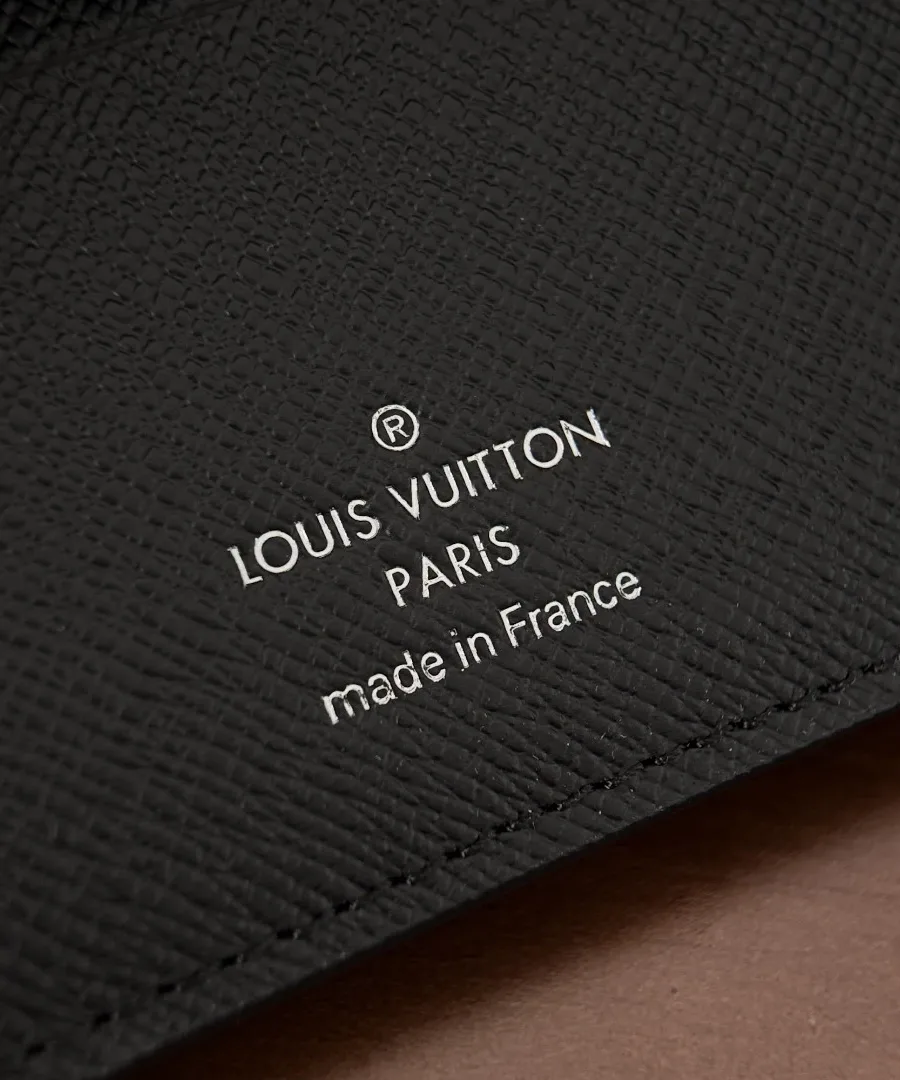 Крупный план серебристого тиснения Louis Vuitton Paris внутри портмоне