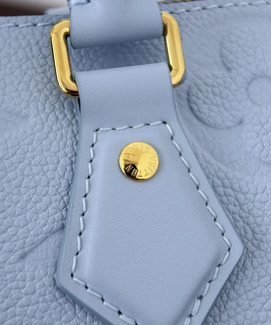 Деталь крепления ручки голубой сумки Louis Vuitton Speedy 20 с золотистой фурнитурой