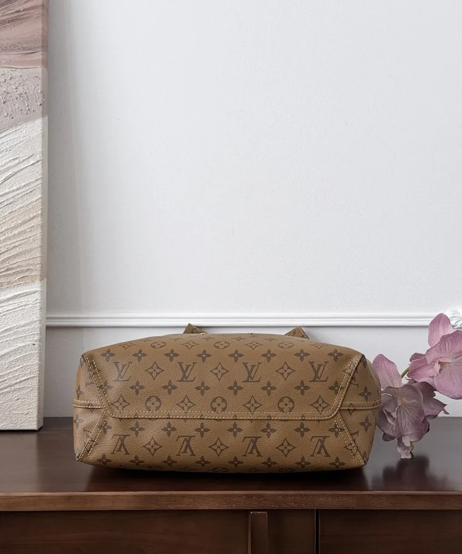 Дно коричневой сумки Louis Vuitton Atlantis GM из канвы Monogram.