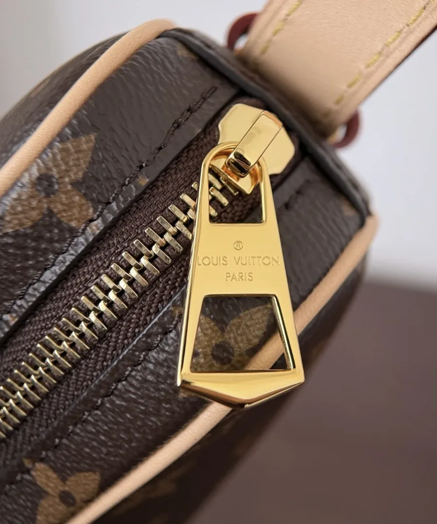 Золотистая застежка-молния с гравировкой Louis Vuitton на сумке, крупный план