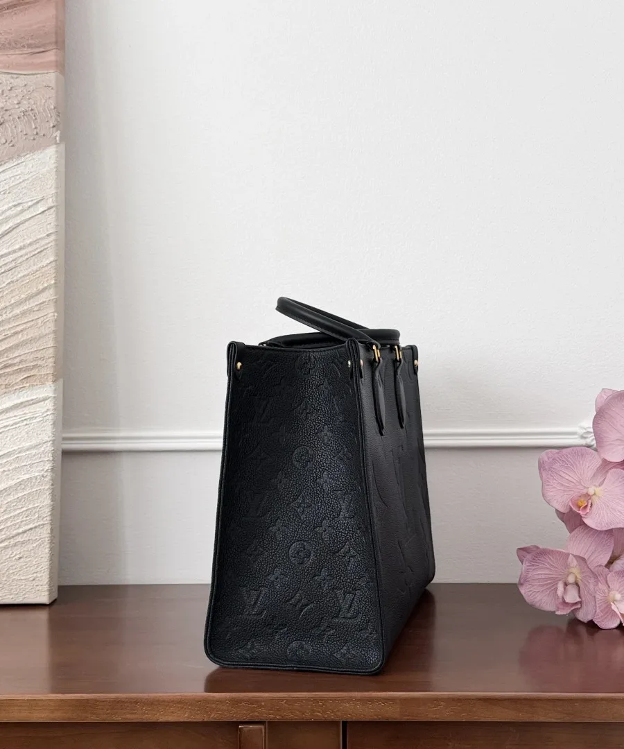 Черная сумка-тоут Louis Vuitton OnTheGo MM, вид сбоку, демонстрирующий тисненый узор