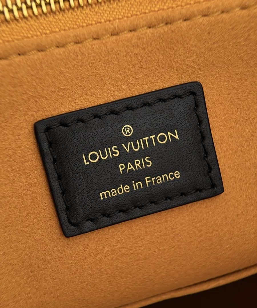 Крупный план кожаной нашивки с золотистым тиснением Louis Vuitton Paris на горчичной подкладке