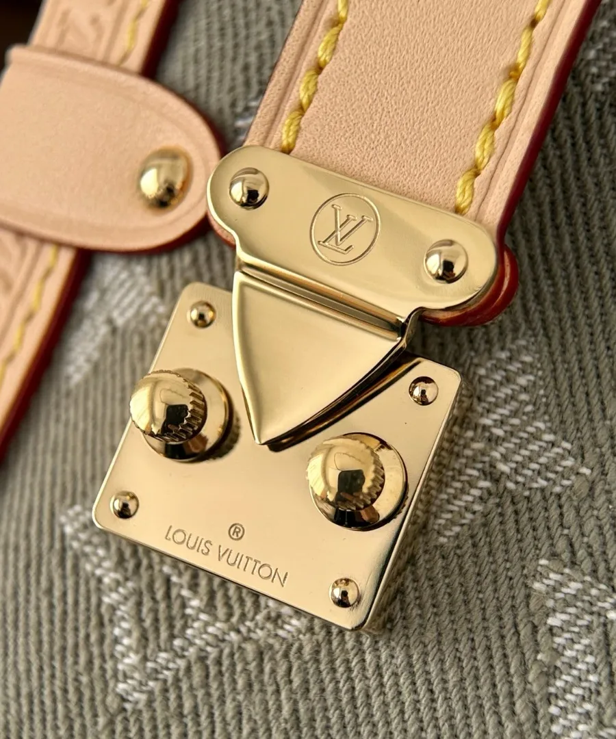 Крупный план золотистого замка S-lock на кожаной отделке сумки Louis Vuitton