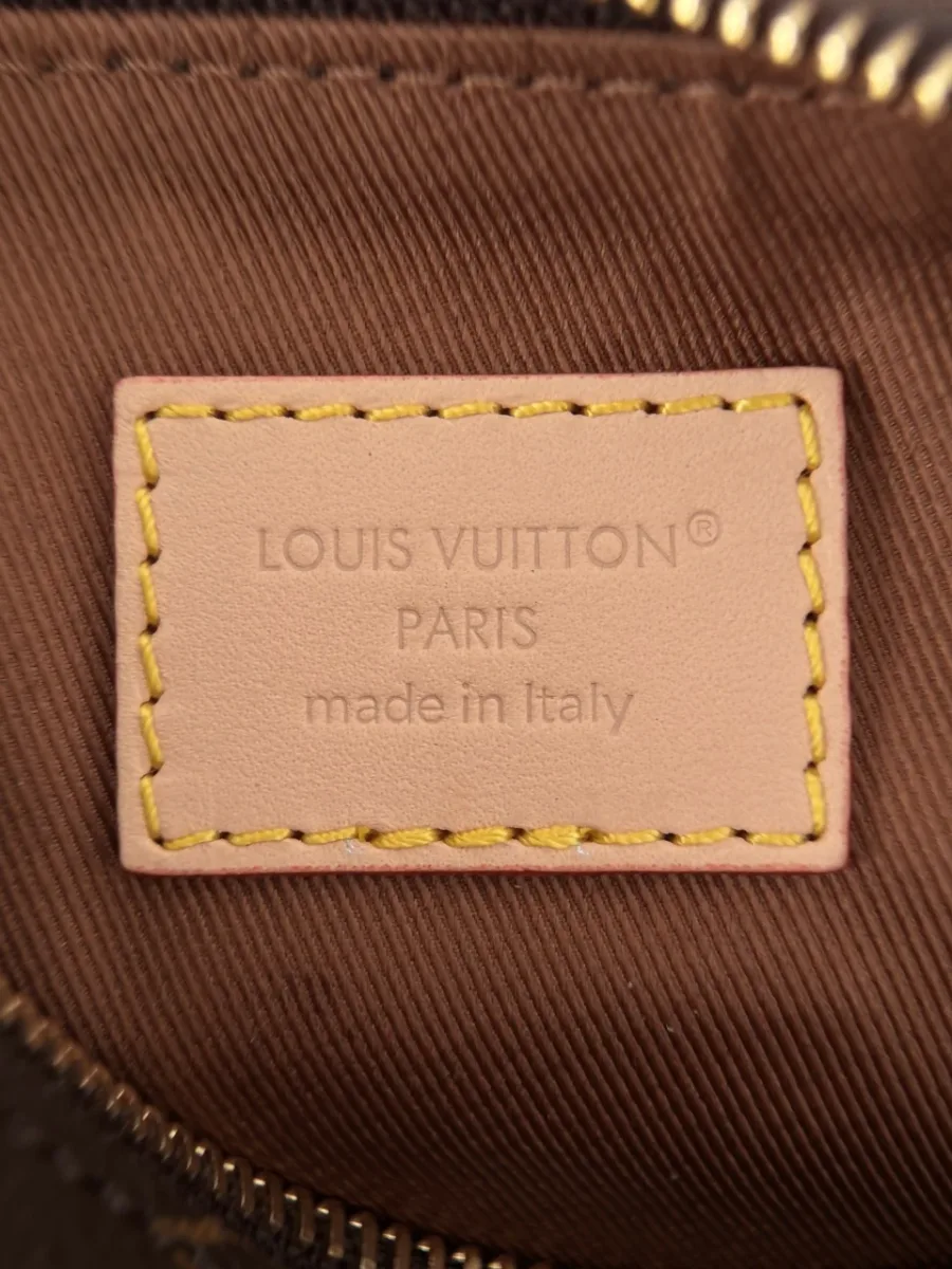 Крупный план кожаной нашивки с тиснением Louis Vuitton внутри сумки