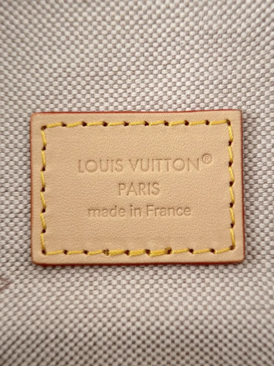 Крупный план кожаной нашивки с тиснением Louis Vuitton Paris внутри сумки