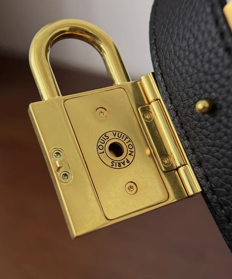 Деталь крепления золотистого замка с гравировкой Louis Vuitton