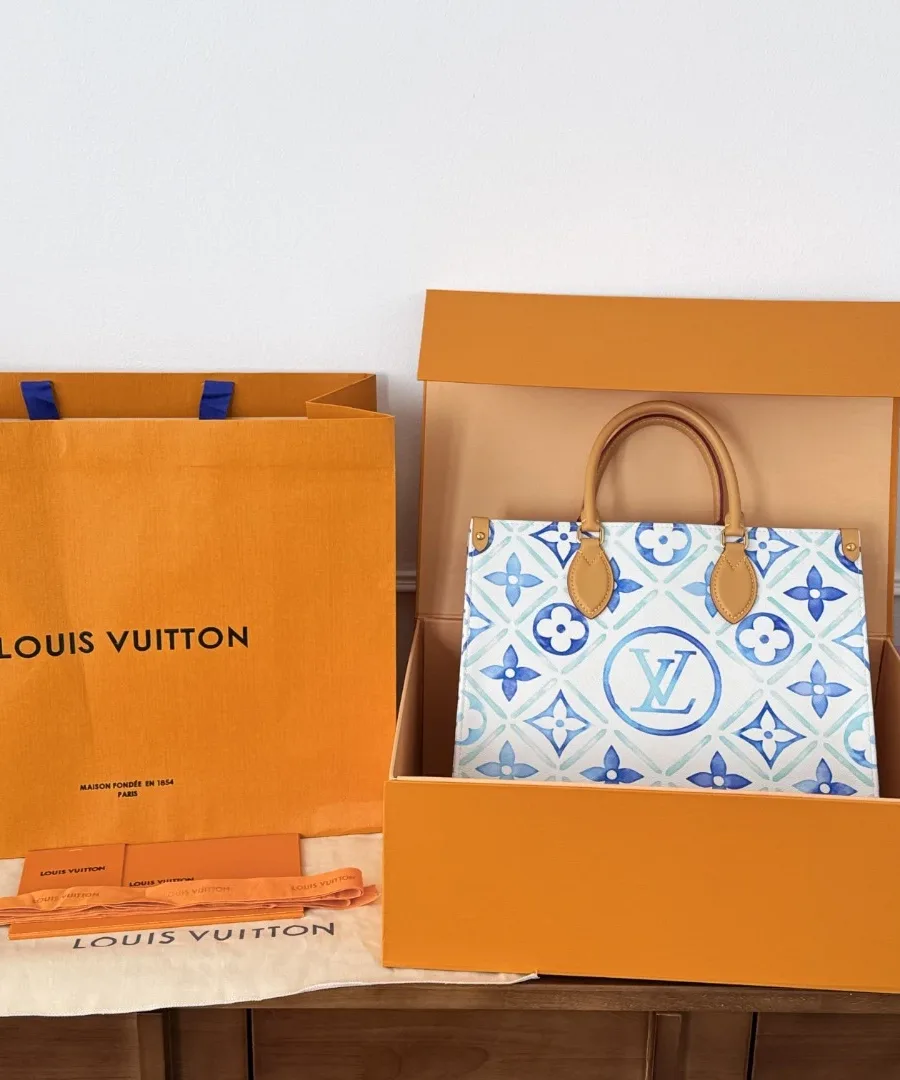 Сумка Louis Vuitton Onthego MM рядом с фирменной коробкой и пакетом