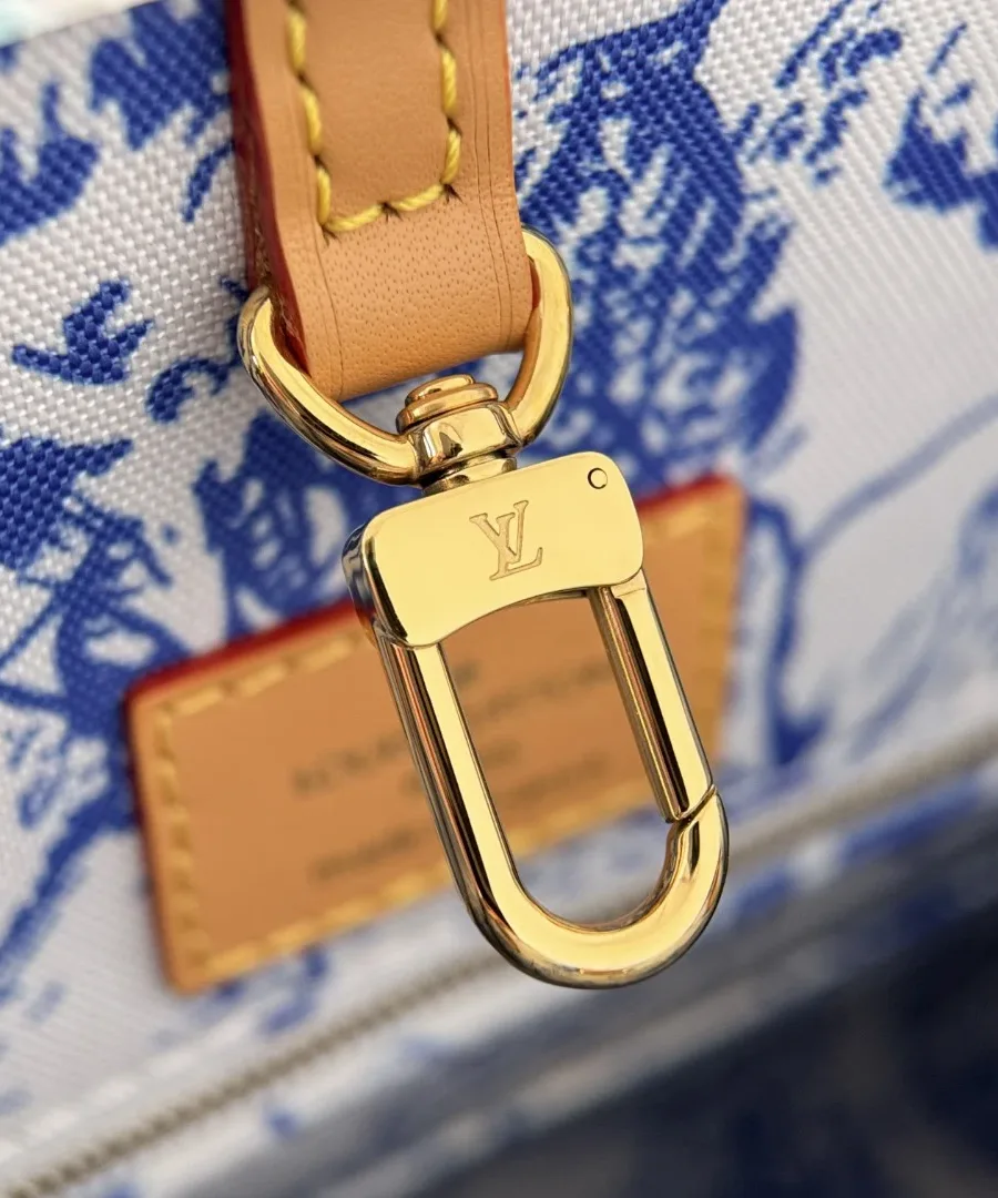 Золотистый карабин с гравировкой LV внутри сумки-тоут Louis Vuitton
