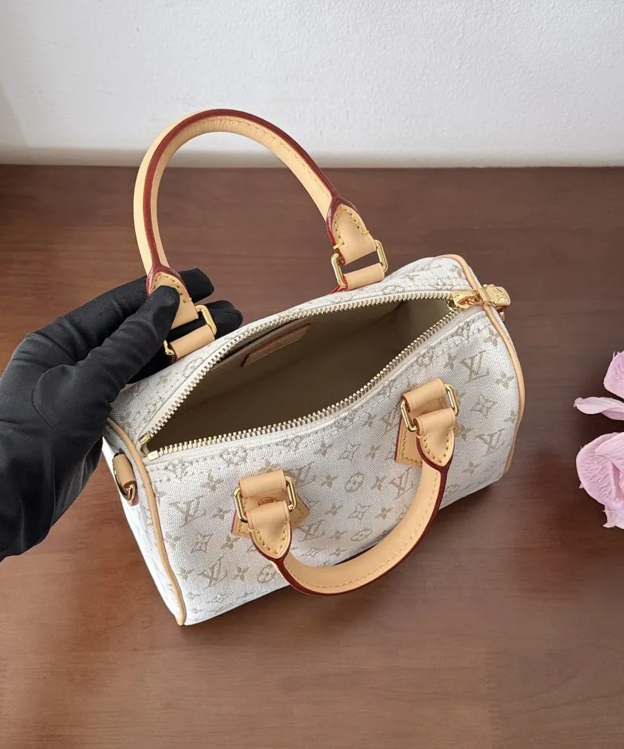 Вид сверху на открытую сумку Louis Vuitton Speedy 20 в руке в черной перчатке