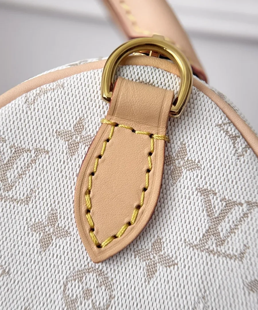Крупный план кожаного крепления с золотистым полукольцом на сумке Louis Vuitton