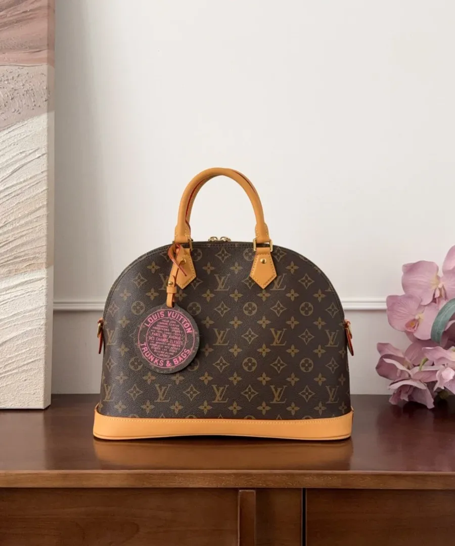 Сумка Louis Vuitton Alma Monogram с круглым розовым брелоком, вид спереди