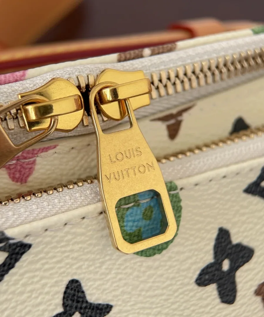Крупный план двойной молнии с золотистыми пуллерами и гравировкой Louis Vuitton