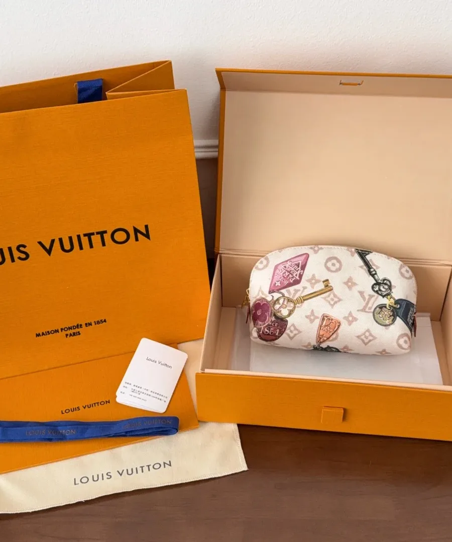 Косметичка Louis Vuitton в фирменной коробке рядом с пыльником и пакетом