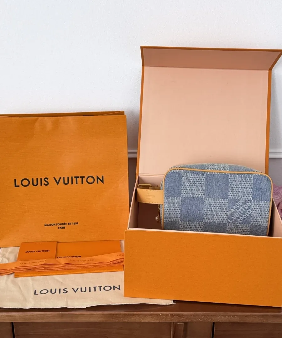 Косметичка Dopp Kit рядом с фирменной коробкой и пакетом Louis Vuitton