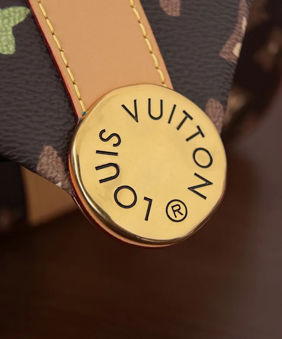Крупный план круглой золотистой детали с гравировкой Louis Vuitton