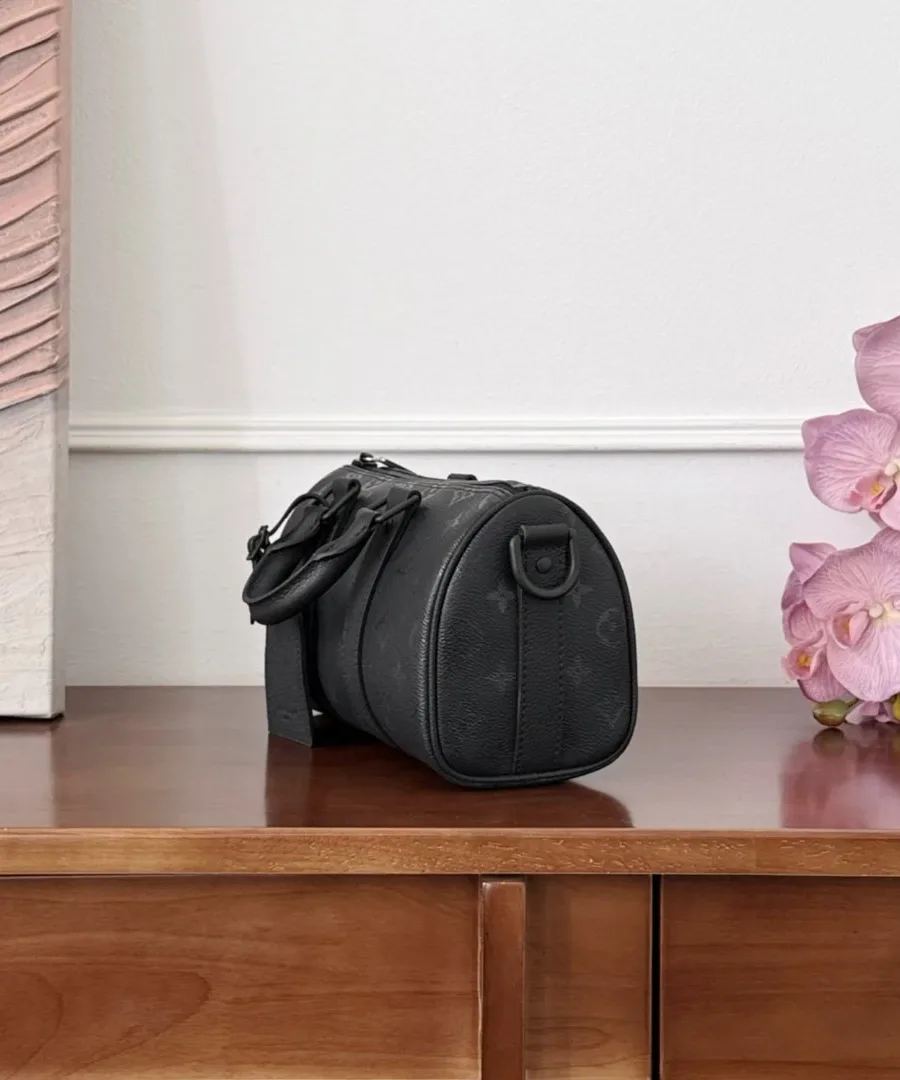 Вид сбоку чёрной сумки Louis Vuitton Keepall 25 цилиндрической формы